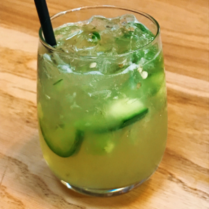 a cocktail made with cucumber and jalapenos on ice